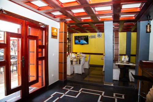 雅温得Hotel Le Kremlin Yaoundé的一间在房间内配有桌椅的餐厅