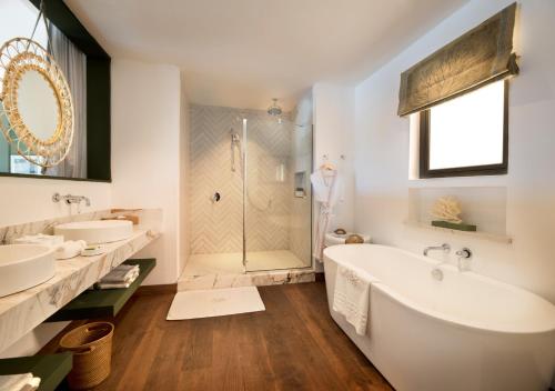 Poste LafayetteLa Maison d'Eté Hotel by NEWMARK的浴室配有2个盥洗盆、浴缸和淋浴。