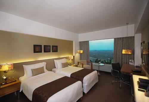 艾哈迈达巴德Fortune Select SG Highway, Ahmedabad - Member ITC's Hotel Group的酒店客房设有两张床和大窗户。