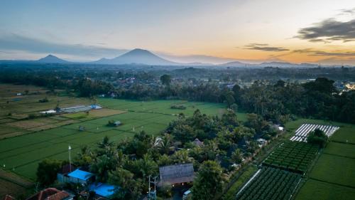 乌布Arya Villas Ubud的享有村庄的空中景色,以群山为背景