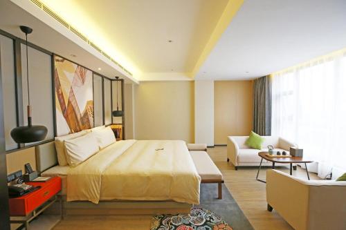 成都成都太古里亚朵S酒店的酒店客房设有一张大床和一张沙发。