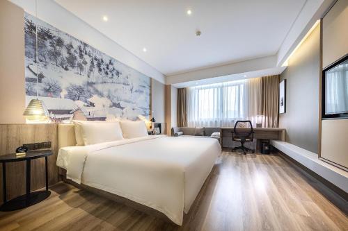 上海上海虹桥枢纽国展中心亚朵酒店的卧室配有一张白色大床和一张书桌