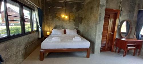 Khwaithai Resort & Homestay - ควายไทย的卧室配有1张床、1张桌子和1把椅子