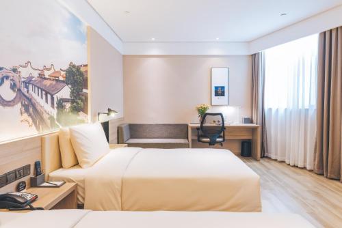 上海上海新国际博览中心磁悬浮站亚朵酒店的酒店客房配有两张床和一张书桌