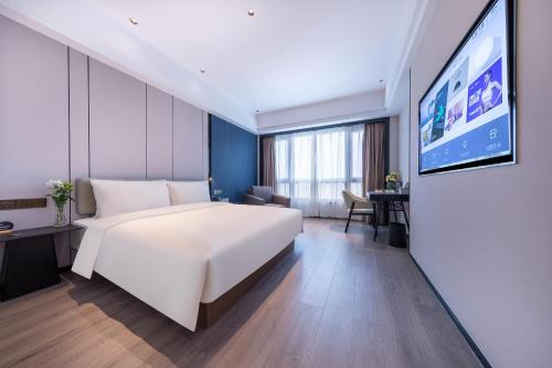 宁波宁波火车站柳汀街亚朵X酒店的一间酒店客房,配有一张大床和一台平面电视