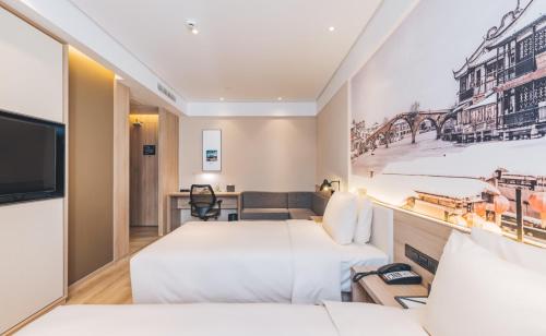 上海上海新国际博览中心磁悬浮站亚朵酒店的一间酒店客房,设有两张床和电视