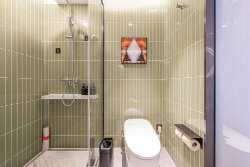 北京北京天安门王府井步行街亚朵酒店的绿色瓷砖浴室设有卫生间和淋浴。