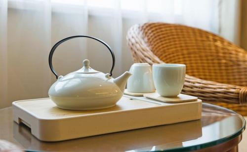 南京南京新街口王府大街亚朵酒店的茶壶和玻璃桌上的两个杯子