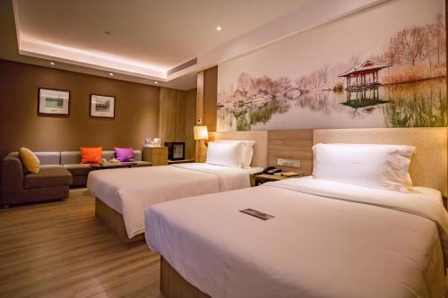 济南济南高新万达广场天辰路亚朵酒店的酒店客房,设有两张床和一张沙发