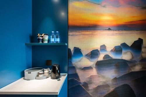 宝安深圳宝安国际机场亚朵酒店的浴室设有一幅海洋画和水槽