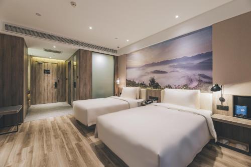 重庆重庆江北机场亚朵酒店的一间酒店客房,设有两张床和电视