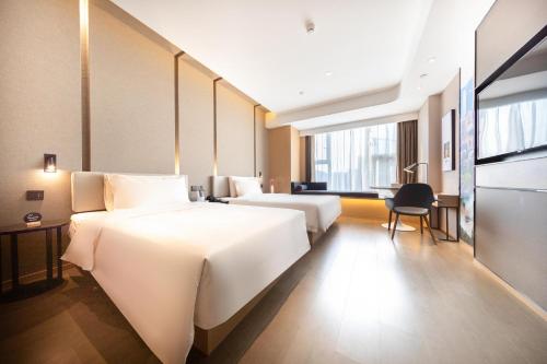 济南济南工业南路CBD亚朵酒店的酒店客房配有两张床和一张书桌
