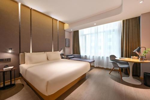 长春长春汽开区西湖大路亚朵酒店的酒店客房设有一张大床和一张书桌。