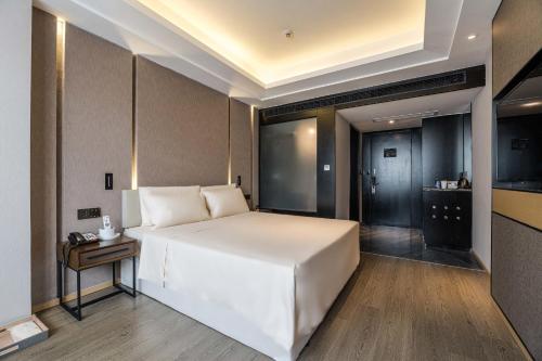 福州福州三坊七巷乌山路亚朵酒店的卧室配有一张白色的大床和一张桌子