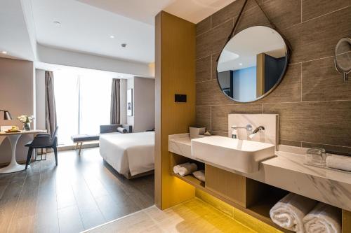成都成都太古里未来中心亚朵酒店的浴室设有床、水槽和镜子