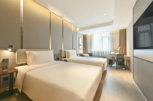 北京北京朝阳路大悦城亚朵酒店的酒店客房设有两张床和电视。