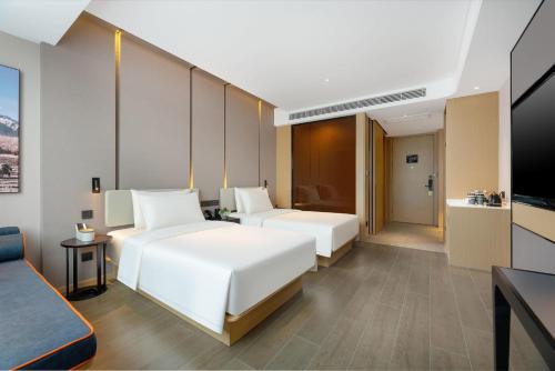 济南济南遥墙国际机场亚朵酒店的酒店客房设有两张床和电视。