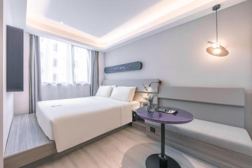 上海上海陆家嘴第一八佰伴轻居酒店的酒店客房配有一张床铺和一张桌子。