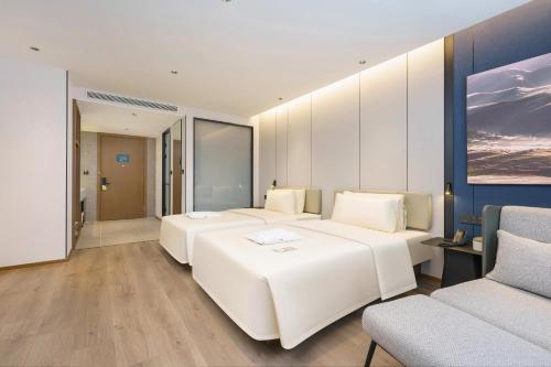 大连大连机场亚朵酒店的酒店客房,设有两张床和一张沙发