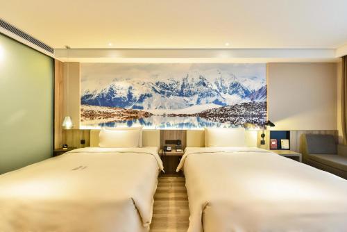 北京北京首都机场亚朵酒店的两张位于酒店客房的床,墙上挂着一幅画