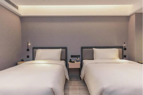 重庆重庆解放碑洪崖洞江景亚朵S酒店的两张睡床彼此相邻,位于一个房间里