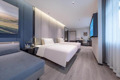长沙长沙东塘亚朵酒店的酒店客房,设有两张床和一张沙发