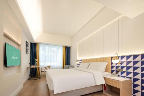 宝安深圳机场宝安益田广场亚朵X酒店的一间酒店客房,配有一张床和一台电视