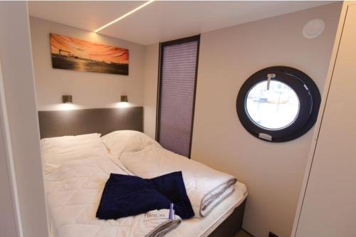 石勒苏益格Hausboot Fjord Aries mit Dachterrasse in Schleswig的卧室配有白色的床和窗户