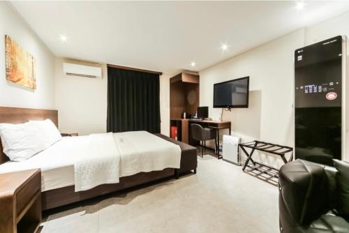 釜山Hotel Egg的酒店客房,配有床和电视