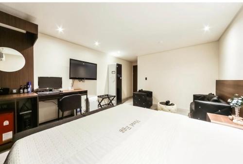 釜山Hotel Egg的卧室配有一张白色大床和一张书桌