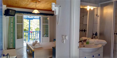 帕蒂迪里奥Galini Hellenic Hospitality的一间带水槽的浴室和一间带浴缸的浴室