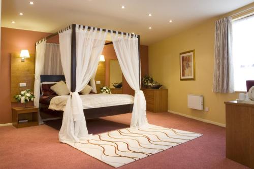 巴恩斯利费尔威新乡村旅馆的一间卧室配有一张带天蓬的床