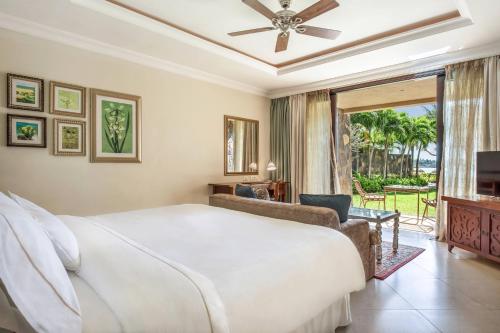巴拉克拉瓦The Westin Turtle Bay Resort & Spa, Mauritius的卧室配有一张白色大床和滑动玻璃门
