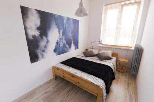 什切青Apartament Wały Chrobrego的卧室配有一张床,墙上挂有绘画作品