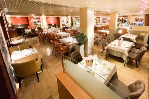 奥格斯堡城市东部酒店的一间带桌椅的餐厅和一间用餐室