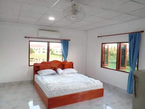 万象Ban Saylomleng Residence的一间卧室配有一张带蓝色窗帘的大床