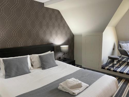 布由德利沃顿公园高尔夫和乡村俱乐部酒店的卧室配有一张白色大床和一把椅子