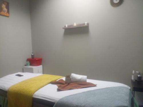 约翰内斯堡DeeCinta Health Spa的一间卧室配有一张床,床上有毛巾