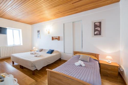 AullèneSan Larenzu的一间卧室设有两张床和木制天花板