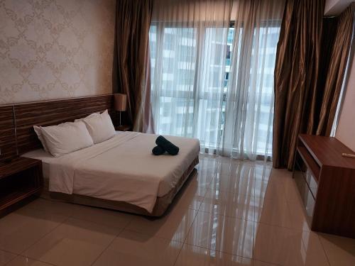 吉隆坡KLCC Regalia Suites Infinity Pool Kuala Lumpur的一间卧室,配有一张带黑色帽子的床