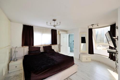 荷兹利亚Luxury villa with a heated pool, Jakuzi and a sea view 70m from the beach的一间卧室配有一张床和一台电视