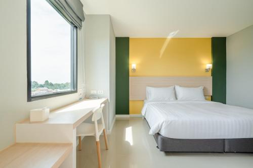 Ban Khao Hin Sonพิลโล่ อินน์ ฉะเชิงเทรา Pillow Inn Chachengsao的一间卧室配有一张床、一张书桌和一个窗户。