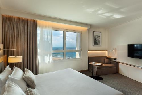 特拉维夫Sea Tower by Isrotel Design的酒店客房设有床和窗户。