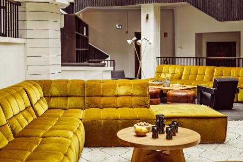 葱仁谷Le Val Thorens, a Beaumier hotel的客厅配有黄色的沙发和桌子