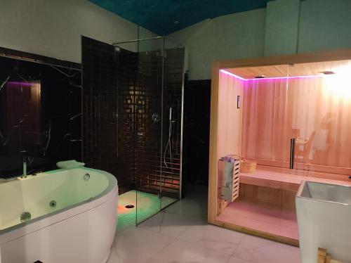 巴罗尼西Setteabbracci Suite & Apartments的带浴缸、淋浴和浴缸的浴室。