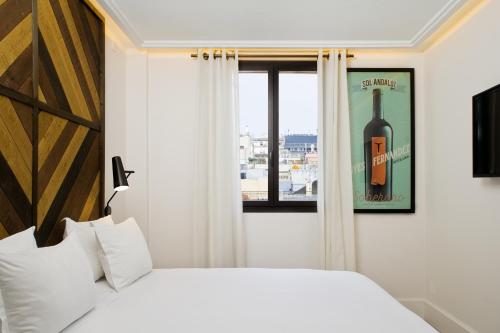 巴塞罗那帕崔克维诺特卡酒店的卧室的窗户上备有一瓶葡萄酒