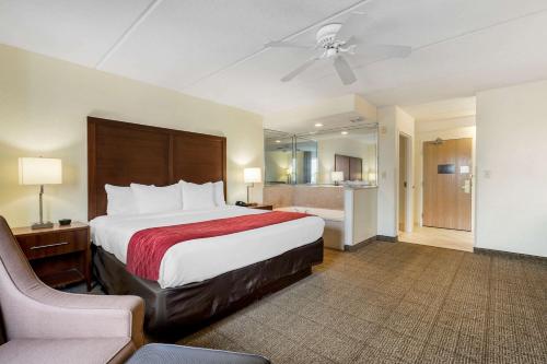 基西米Comfort Inn Kissimmee-Lake Buena Vista South的大型酒店客房,配有床和椅子