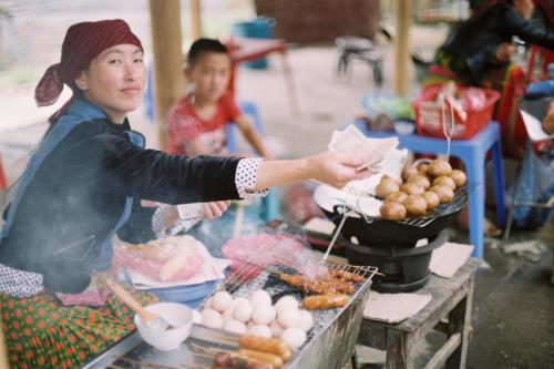 河江Rainbow House Ha Giang的女人在市场上做饭