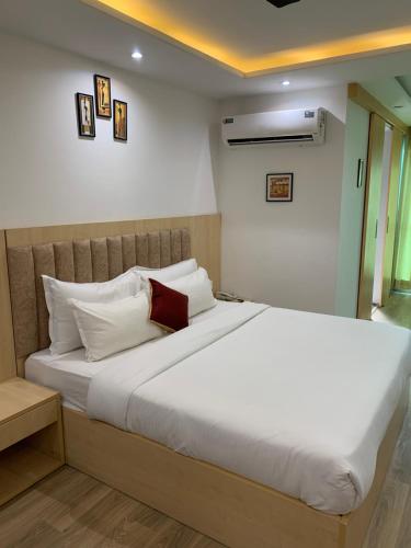斋浦尔Balconies & Venue ( The Grand Anukampa)的卧室配有带白色枕头的大床