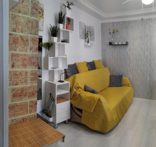 里加Frendly Flat Free Parking Kitchen Equipment Cosy的一间卧室设有黄色的床和砖墙